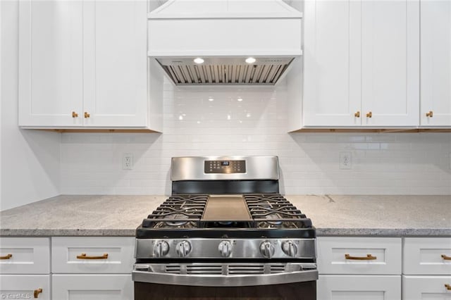 kitchen with white cabinetry, stainless steel gas stove, and light stone counters