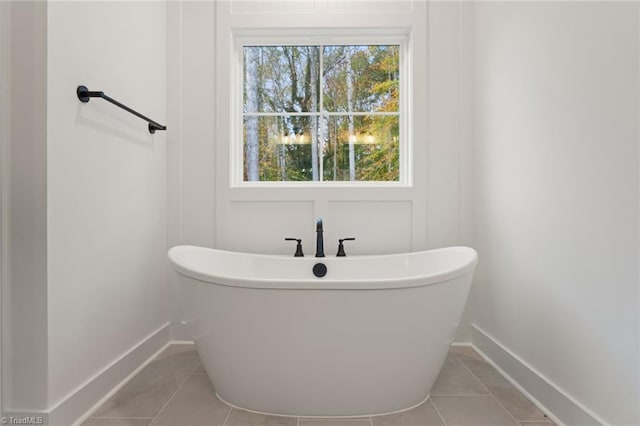 bathroom with a bath and tile patterned flooring