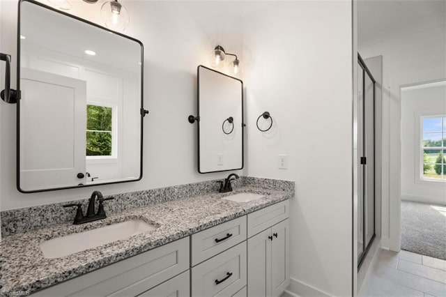 bathroom with tile patterned floors, vanity, and a shower with door