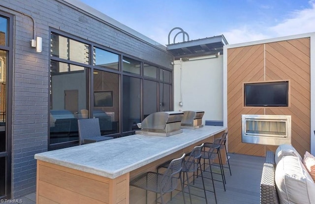 view of patio / terrace featuring outdoor wet bar, grilling area, and an outdoor kitchen
