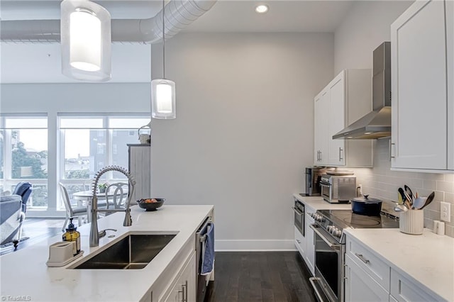 400 W 4th St Unit 401, Winston-Salem, NC 27101 - kitchen with a sink, wall chimney exhaust hood, baseboards, appliances with stainless steel finishes, and dark wood-style floors