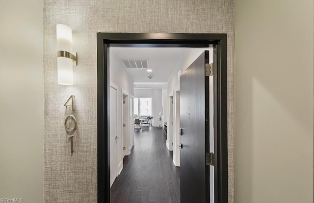 hall featuring visible vents and dark wood finished floors
