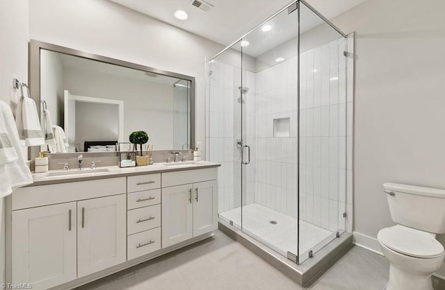 bathroom with toilet, visible vents, a shower stall, and a sink