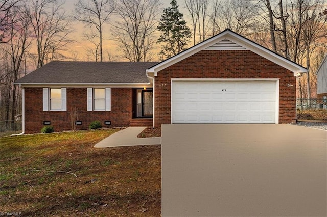 ranch-style home with an attached garage, brick siding, a shingled roof, concrete driveway, and crawl space