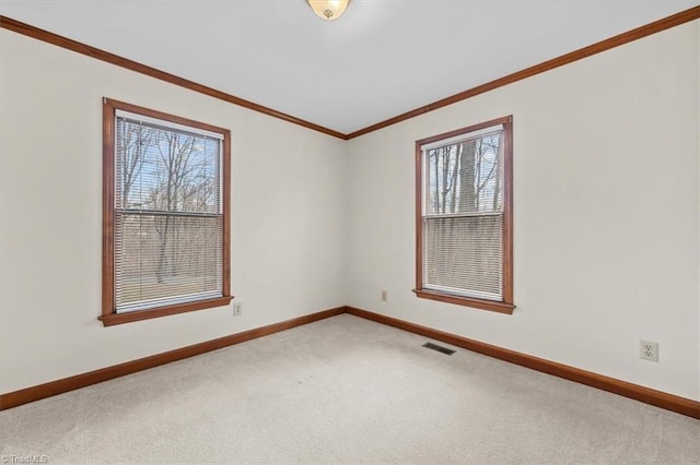 unfurnished room featuring light carpet, ornamental molding, visible vents, and baseboards