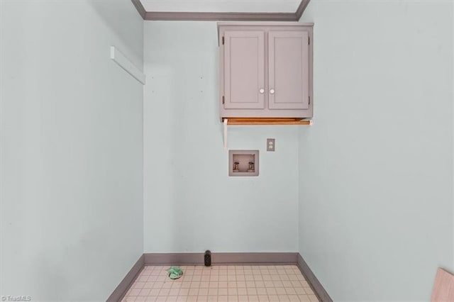 clothes washing area featuring crown molding, washer hookup, cabinet space, and baseboards