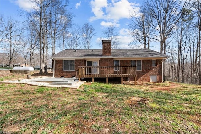 rear view of property with a patio area, a wooden deck, a chimney, and brick siding