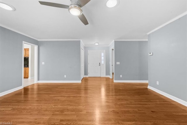 unfurnished living room featuring ceiling fan, baseboards, wood finished floors, and ornamental molding