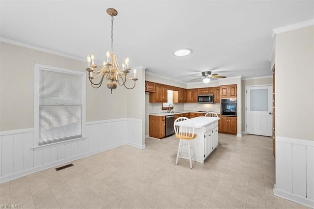 kitchen with visible vents, light countertops, appliances with stainless steel finishes, wainscoting, and brown cabinets