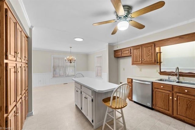 kitchen with stainless steel dishwasher, brown cabinetry, wainscoting, and a sink