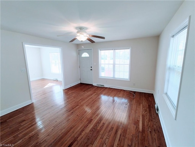 foyer with a wealth of natural light, dark wood-style flooring, visible vents, and baseboards