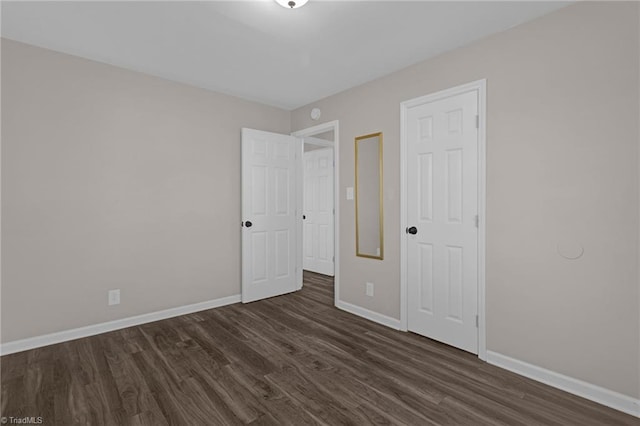 unfurnished bedroom with dark wood-type flooring