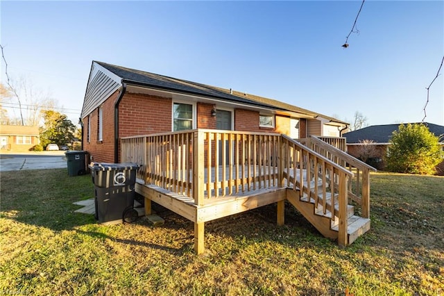 rear view of house with a yard and a wooden deck