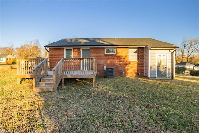 rear view of property featuring central air condition unit, a wooden deck, and a yard