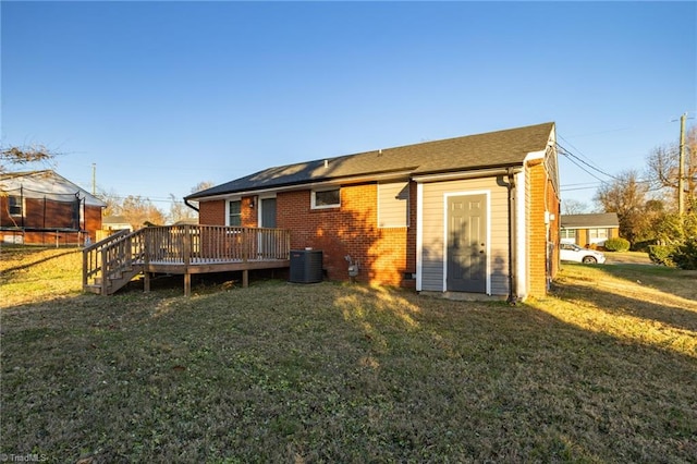 back of property featuring a lawn, cooling unit, a deck, and a trampoline