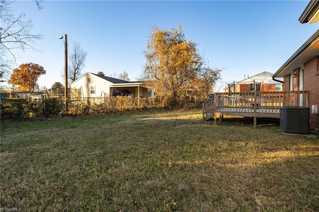 view of yard with central air condition unit and a wooden deck