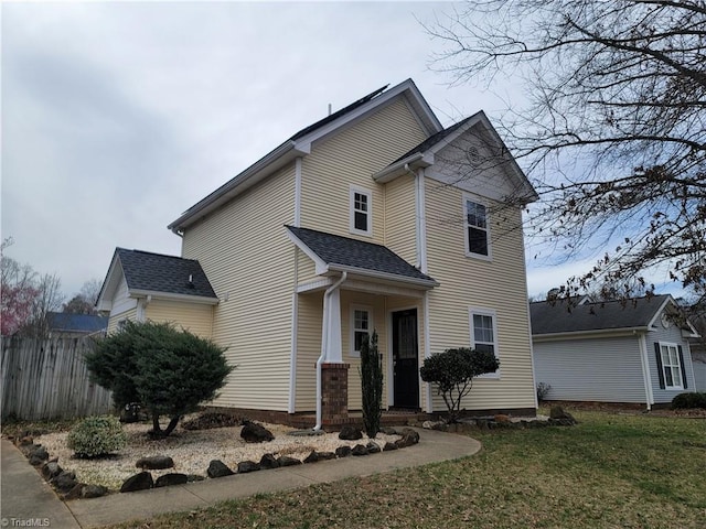 view of front facade with a front yard and fence