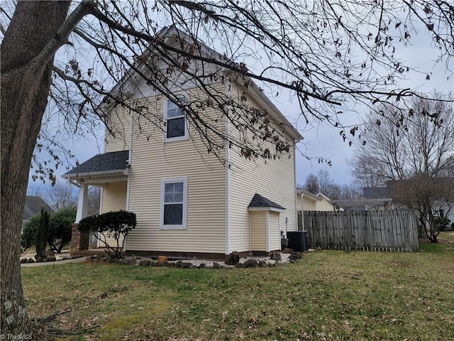 view of property exterior featuring a yard, central AC unit, and fence