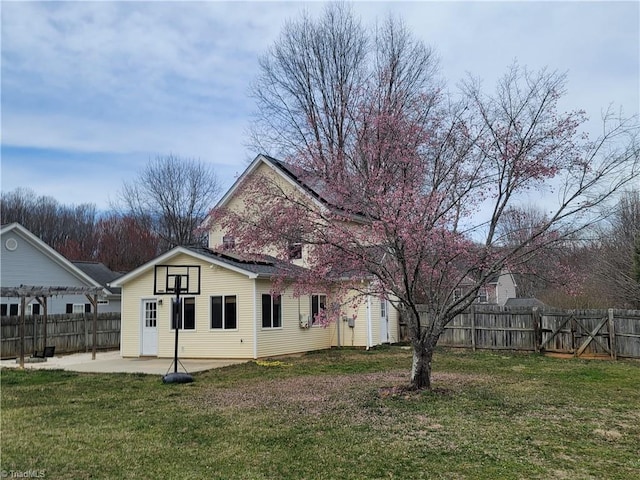 exterior space with a yard, a fenced backyard, and a patio area