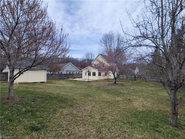 view of yard featuring a storage shed, an outdoor structure, a fenced backyard, and a patio area