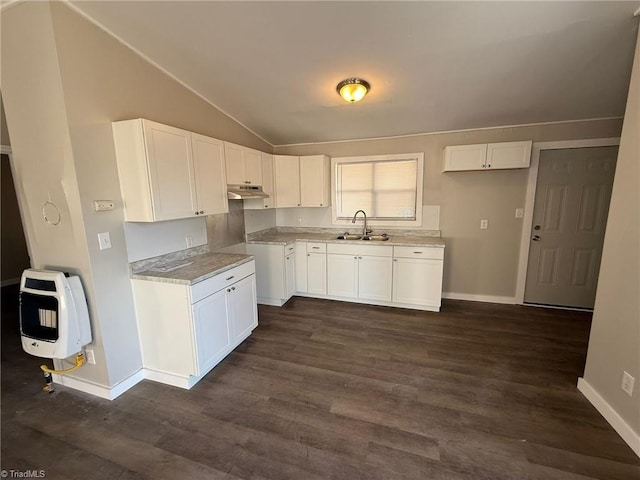 kitchen featuring heating unit, white cabinetry, vaulted ceiling, a sink, and under cabinet range hood