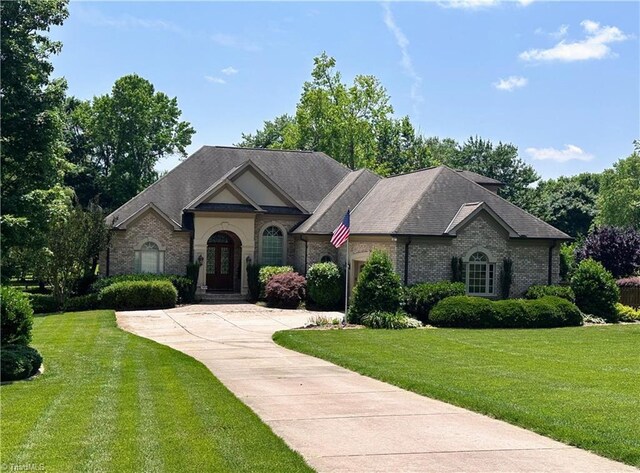 2863 Spencer Rd, Archdale, NC 27263 - french provincial home featuring a front yard, brick siding, and driveway