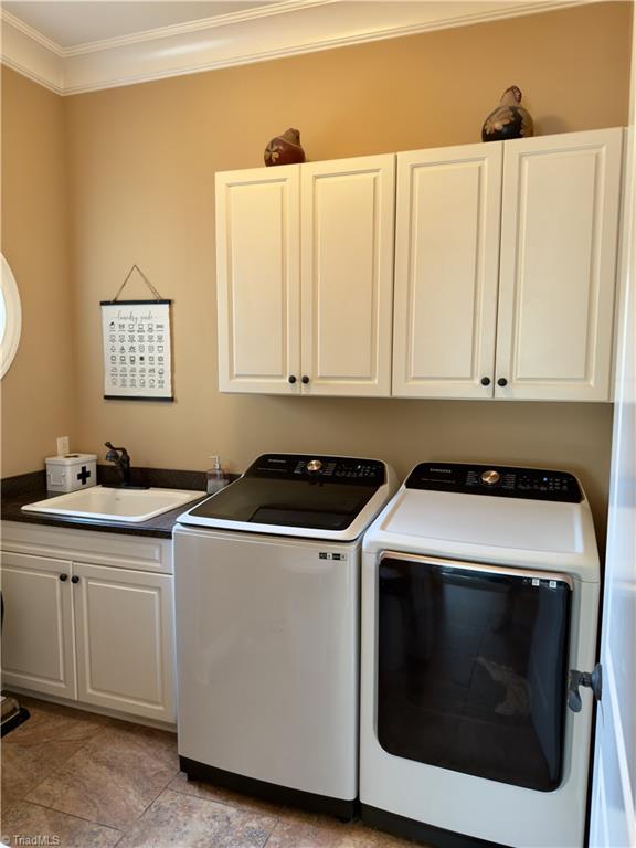 2863 Spencer Rd, Archdale, NC 27263 - laundry area with crown molding, washer and dryer, and cabinet space