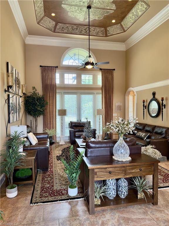 2863 Spencer Rd, Archdale, NC 27263 - living area with a towering ceiling, a ceiling fan, a tray ceiling, and ornamental molding