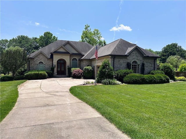 2863 Spencer Rd, Archdale, NC 27263 - french country style house featuring a garage, a front yard, driveway, and brick siding