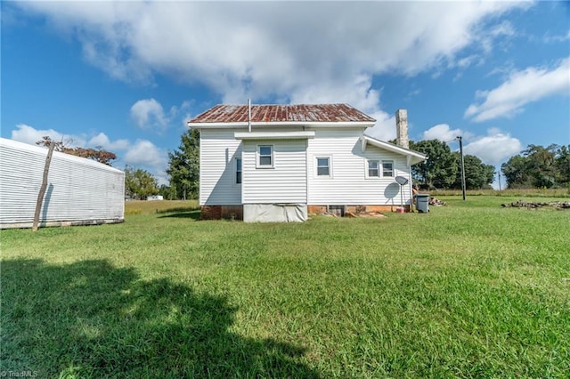 rear view of house featuring a yard