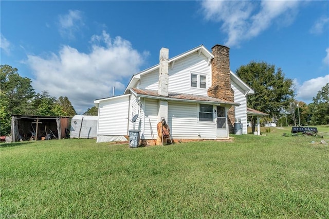 rear view of property featuring a yard and a chimney