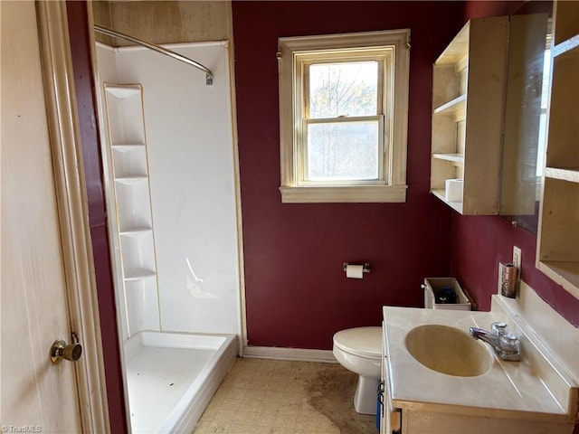 bathroom with vanity, toilet, baseboards, and a stall shower