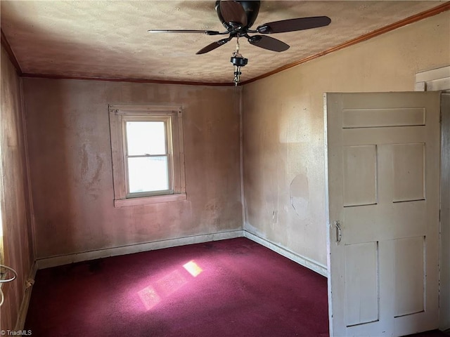 empty room featuring ceiling fan, a textured ceiling, baseboards, and ornamental molding