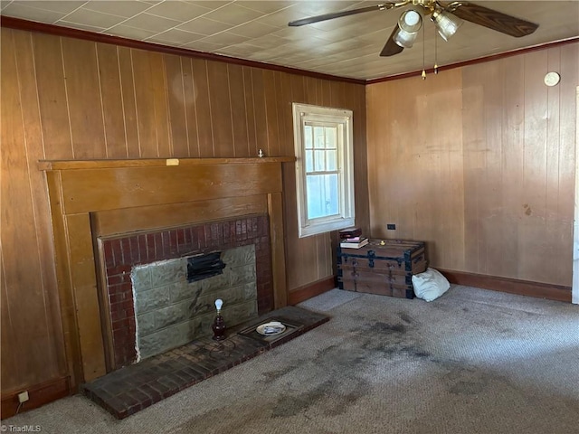 unfurnished living room with wooden walls, carpet, ceiling fan, and a fireplace