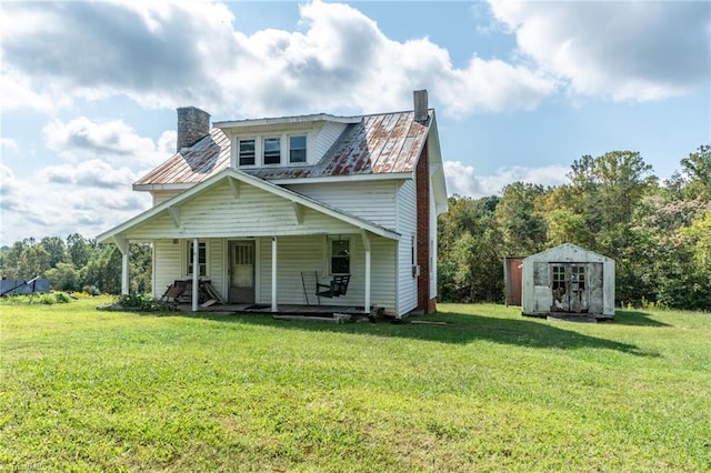 view of front of property featuring an outbuilding, a front lawn, a porch, a shed, and a chimney