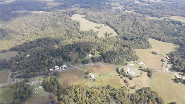 drone / aerial view featuring a rural view and a wooded view