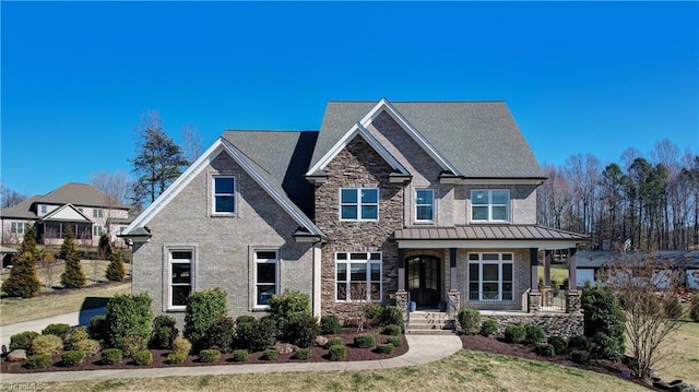 craftsman-style house featuring a standing seam roof, stone siding, metal roof, and brick siding