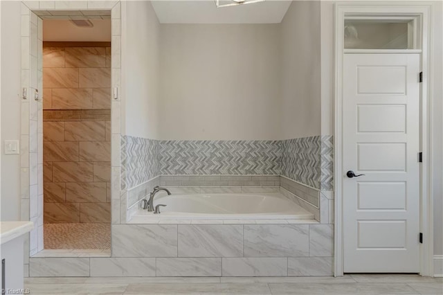 full bath with a tile shower and a bath