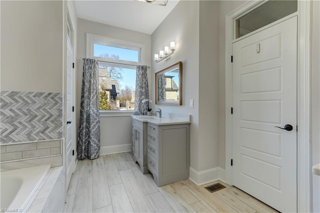 bathroom featuring vanity, visible vents, a wealth of natural light, and wood finished floors