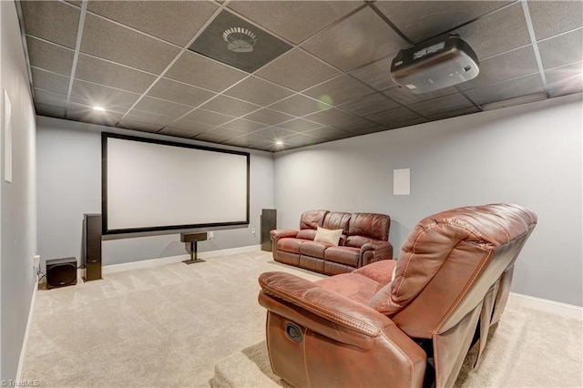 cinema room with a paneled ceiling, baseboards, and carpet flooring