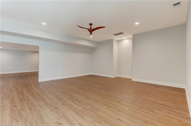 empty room with a ceiling fan, visible vents, light wood-style flooring, and baseboards