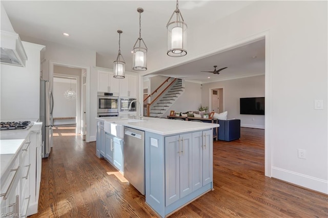 kitchen featuring dark wood-style flooring, appliances with stainless steel finishes, white cabinets, and light countertops