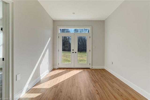 entryway featuring french doors, light wood finished floors, a wealth of natural light, and baseboards