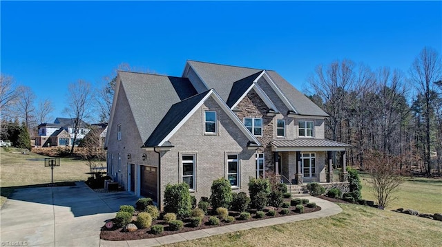 view of front of house featuring brick siding, a standing seam roof, concrete driveway, and a front yard