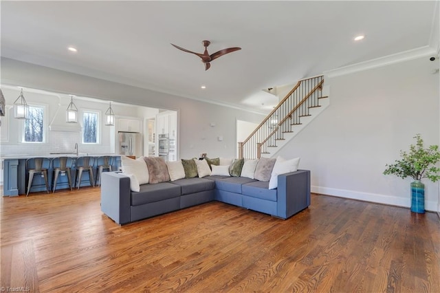 living room featuring stairway, wood finished floors, and crown molding