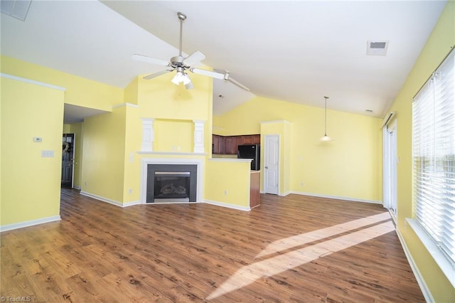 unfurnished living room featuring ceiling fan, high vaulted ceiling, wood finished floors, and a fireplace