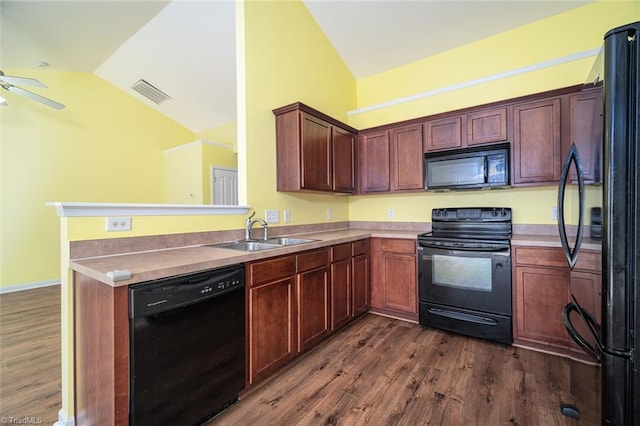 kitchen featuring visible vents, dark wood finished floors, vaulted ceiling, black appliances, and a sink