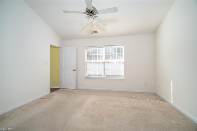 carpeted spare room with a ceiling fan, baseboards, and visible vents