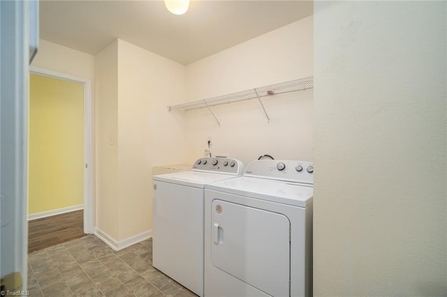 washroom with washer and dryer, baseboards, and laundry area