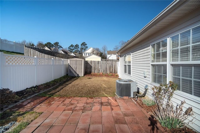 view of patio with cooling unit, an outdoor structure, a fenced backyard, and a shed